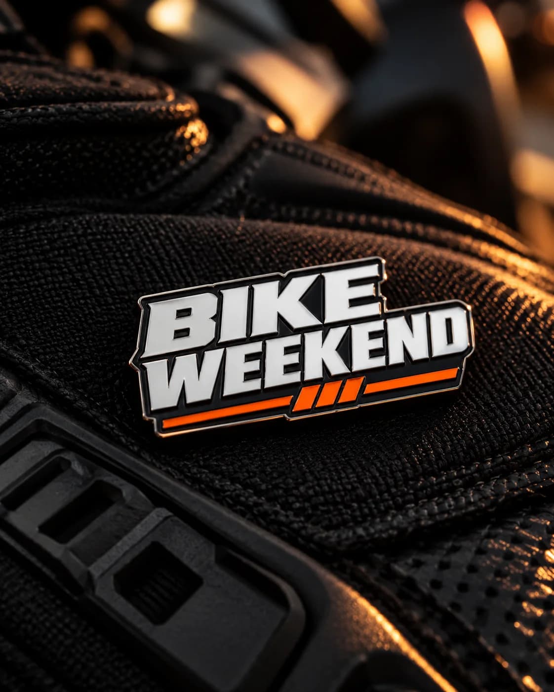 Pin metálico Bike Weekend sobre una chaqueta de moto